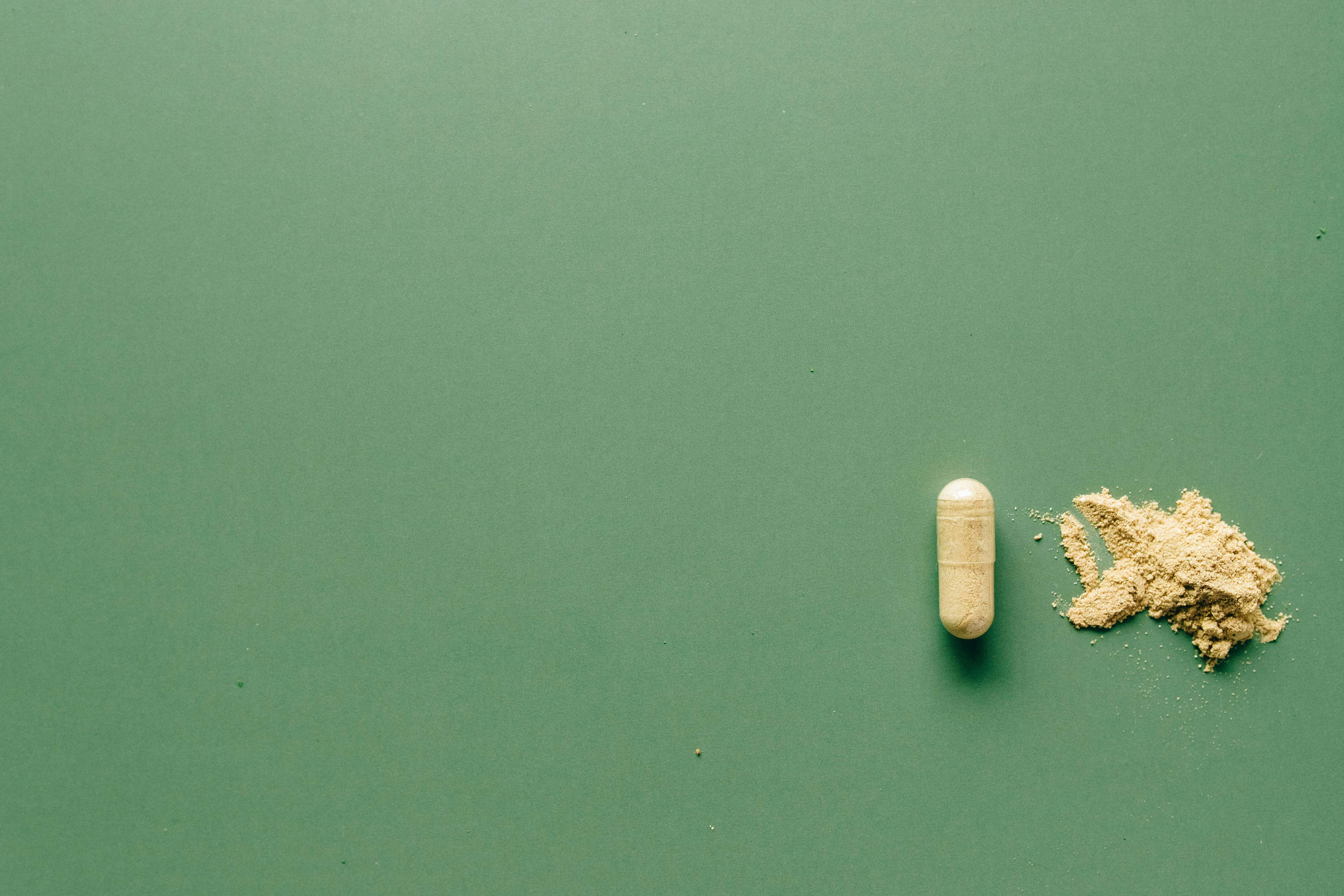 kratom capsule on green background